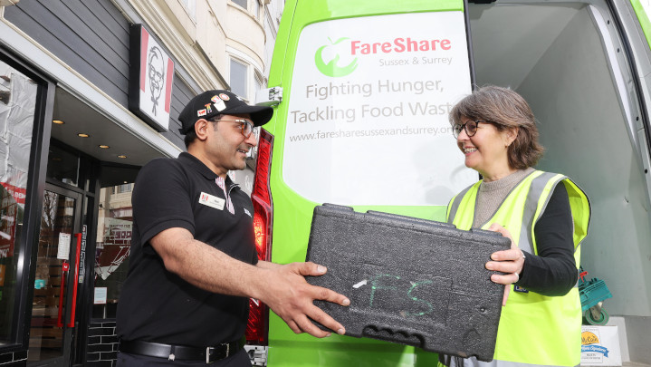 kfc worker handing fareshare volunteer donated food