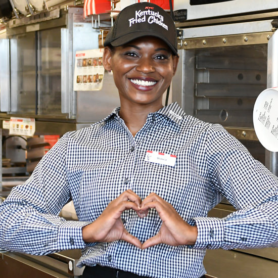 A KFC associate makes a heart shape with her hands A KFC associate makes a heart shape with her hands