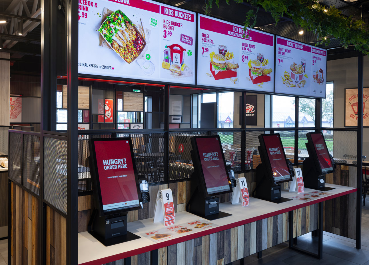 A row of KFC ordering kiosks inside a KFC restaurant